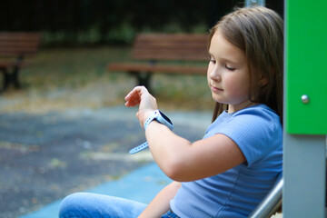 Girl checking smartwatch in park