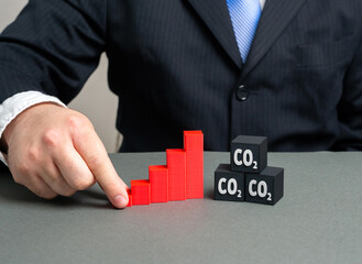 A graph of rising carbon dioxide emissions. A man studies the trend of rising pollution. Global...