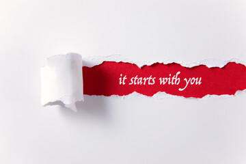 Torn paper background with it starts with you message	