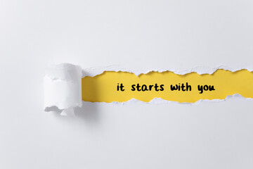 Torn paper background with it starts with you message	