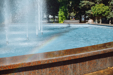 city fountain in the center of Stavropol with a rainbow on the water jets. Sunny day, freshness and positive in the city atmosphere. Ideal for themes: nature, city life, recreation, tourism, ecology
