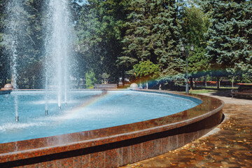 city fountain in the center of Stavropol with a rainbow on the water jets. Sunny day, freshness and positive in the city atmosphere. Ideal for themes: nature, city life, recreation, tourism, ecology