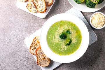 Warm and comforting creamy broccoli soup served in a bowl, garnished with parmesan cheese and...