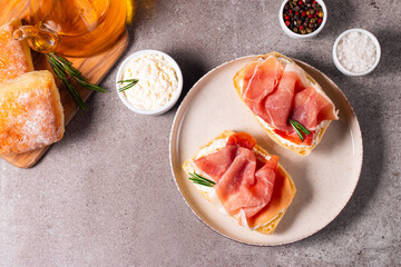 Toast with cream cheese and jamon. Prosciutto crudo open sandwich with rosemary, bread and oil. 