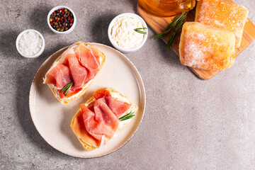 Toast with cream cheese and jamon. Prosciutto crudo open sandwich with rosemary, bread and oil. 