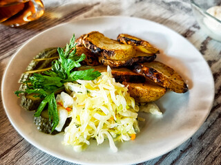 Grilled potatoes served with fresh salad and herbs on a rustic table setting