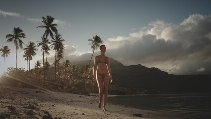 People relax tropical paradise beach on summer holiday vacation. Beautiful woman walks along sandy...