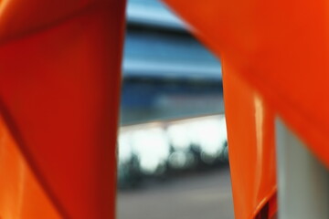 Close-up abstract image of bright orange fabric with folds and blurred background. Minimalist...