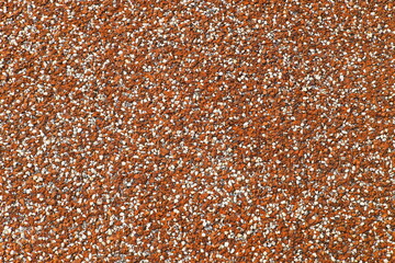 Orange gravel texture closeup, abstract background with small stones and granules, perfect for design and construction concepts.