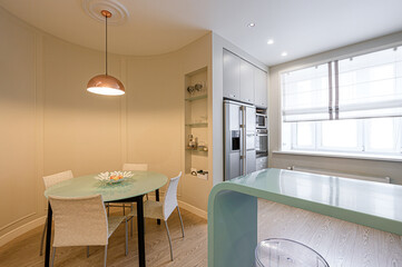 modern, well-lit kitchen and dining area with sleek cabinets and appliances, a unique dining table,...