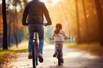 Dad helping his daughter ride a bike bicycle vehicle cycling.
