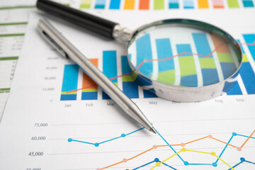 Obraz premium Magnifying glass on data business graphs paper.