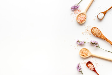 Beauty spa therapy cosmetics and wellness flat lay - sea salt in many spoons with flowers, top view
