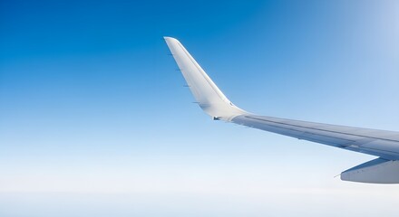 Obraz premium Stunning airplane wing soaring through clear blue sky, symbolizing travel and freedom
