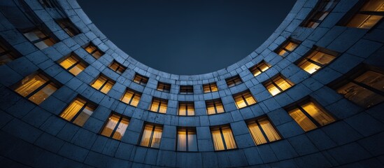 Naklejka premium Curved building at night with lit windows