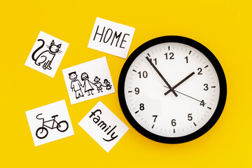 Wall clock and many paper cards with hand drawing of different life activities, top view. Time management concept. Life balance and planning concept.