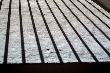 Shadows of wrought-iron grille on Royal Alcazar wall in Seville