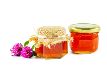 Jars of honey and clover flowers isolated on white background.