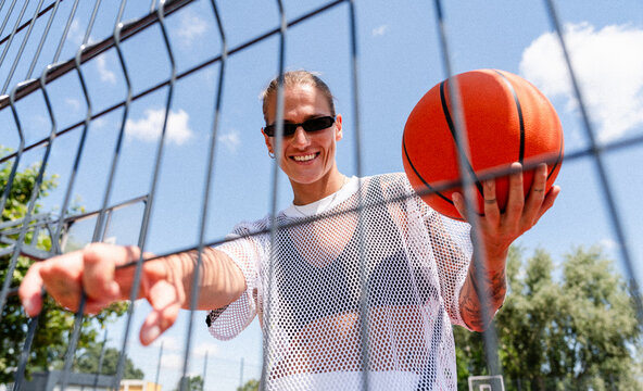 Urban street style woman with basketball at outdoor court