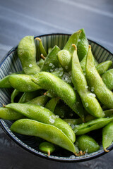 appetizers green edamame with salt on the table.