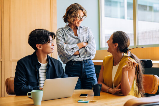 Young professionals engage in joyful conversation during a casual office meeting