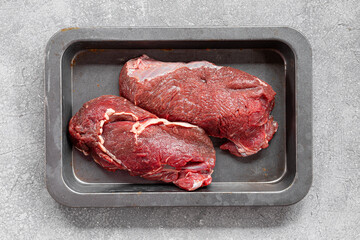 Raw beef meet with herbs and spices ready for cooking on grey background, top view copy space for...