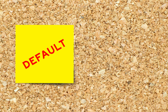 Yellow note paper with word default risk on cork board background with copy space
