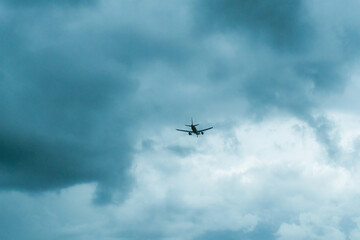 Commercial airplane flying against cloudy sky. Aircraft in air. Travel, vacation, and aviation concept. Global transportation.