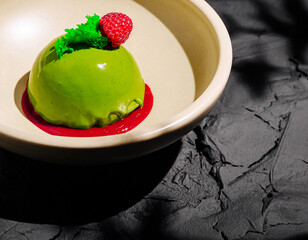 Delicious green dessert served on an elegant plate with fruit garnish