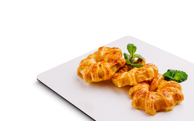 Freshly baked pastries displayed on a white plate with mint garnish