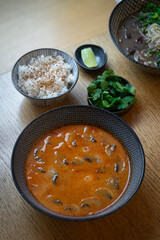 Aromatic tom yum soup served with rice, shrimps, mushrooms., herbs.