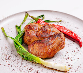 Succulent grilled steak served with fresh green onions and red chili
