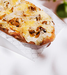 Delicious flatbread topped with cheese and mushrooms served around midday