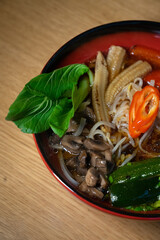 Vegetable asian soup served on table.