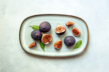 Fresh ripe figs on a plate top view on a gray background
