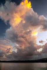Billowing cloud above a lake, highlighted with the colours of a setting sun. Billowing cloud with warm colours of a setting sun above Lake Windermere
