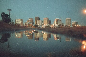 City skyline reflected in water at twilight showcasing modern architecture and vibrant lights in urban landscape