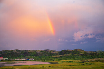 Obraz premium Rainbow in a stormy sky in the Teriberka Nature Park on the Barents Sea coast.