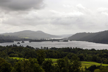 Moody lake scene surrounded by trees, hills and mountains, Lake Windermere, The Lake District, Cumbria, England