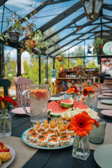 Summer table setting with colorful canap&eacute;s and seasonal fruits.