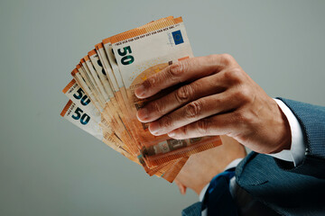 businessman in a suit holds euro banknotes