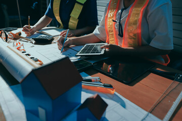 Closeup of team of industrial engineers meeting analyze machinery blueprints consult project on...