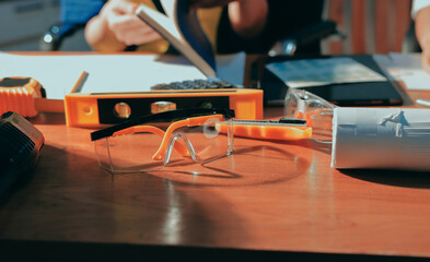 Closeup of team of industrial engineers meeting analyze machinery blueprints consult project on table in manufacturing factory. Working in manufacturing plant or production plant.
