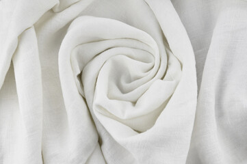 White linen fabric background twisted in the middle. Top view. Full depth of field.