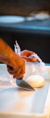 hands knead the raw pizza dough for pizza making