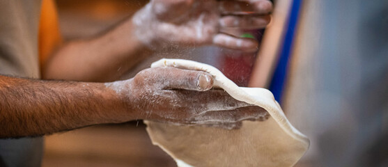 Chef's hands spraying flour over the dough. Kneading dough. chef kitchen dough