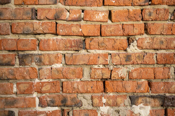 A close-up view of a rustic brick wall showcasing a variety of textures and colors, with some...