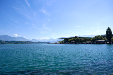 Scenic view of Lake Lucerne with pier and mountain panorama in the background seen from Swiss city of Luzern on a sunny summer noon. Photo taken August 25th, 2025, Lucerne, Switzerland.
