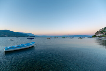 Blue boat on the lake waters and sunrise