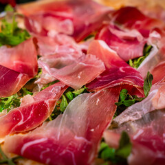 White pizza with prosciutto crudo, arugula and parmesan